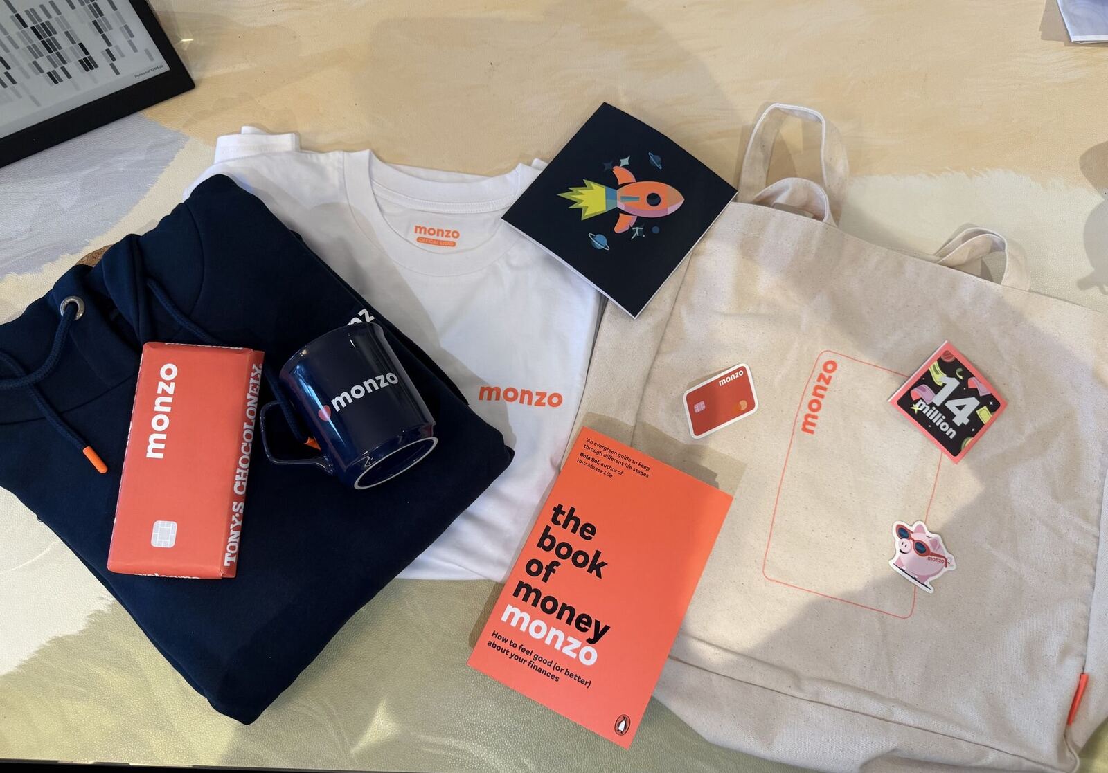 Monzo welcome pack with a hoodie, t-shirt, mug, tote bag, chocolate and The Book of Money